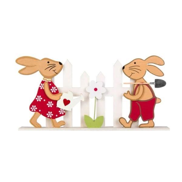 Figurina decor pentru masa de Paste, doi iepurasi in haine rosii de sarbatoare, ingrijind o floare din gradina imprejmuita cu gard, stativ din lemn, lungime 31.5 cm - Topi Toy